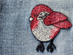 Imagen de pajarito pintado sobre jeans.